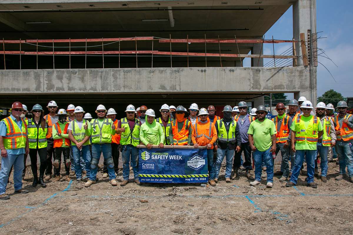 Project team on job site holding Safety Week banner